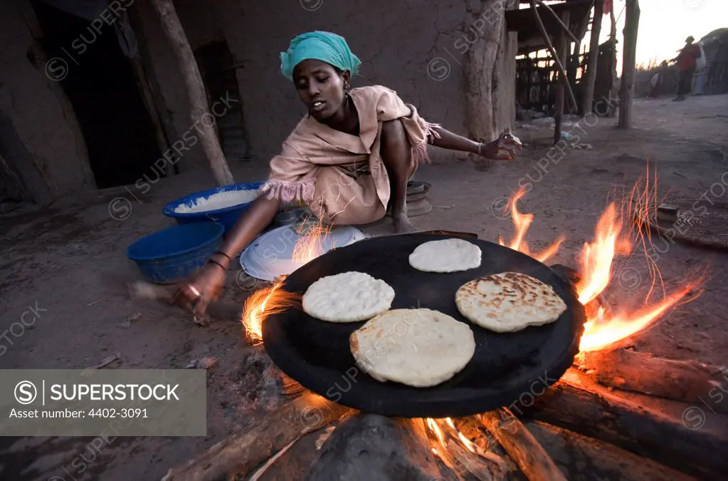 Woman from Afar tribe making ga'ambo maize flat-bread, Bilen, Ethiopia