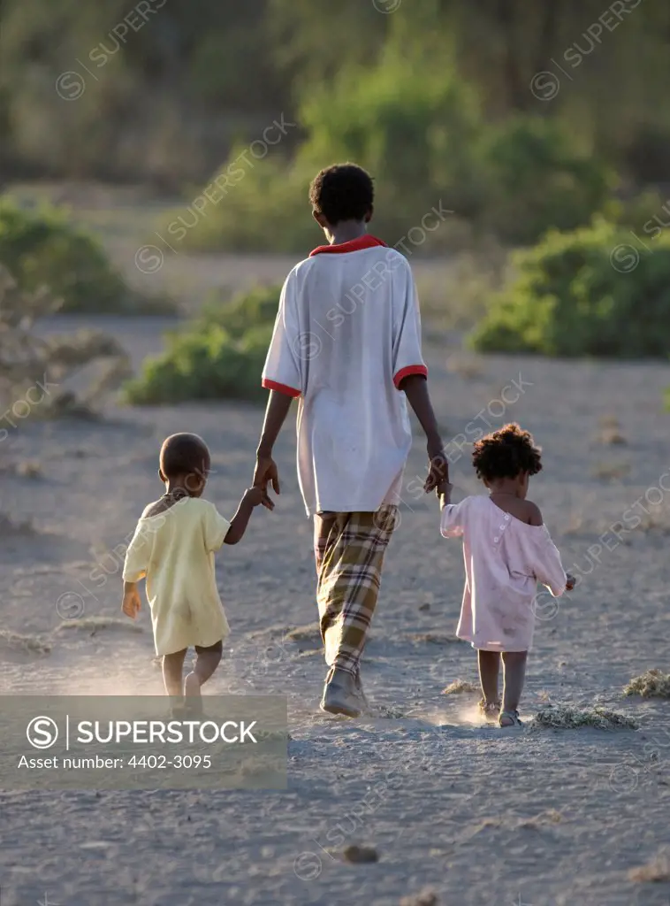 Boy walking with small children, Afar tribe, Bilen, Ethiopia