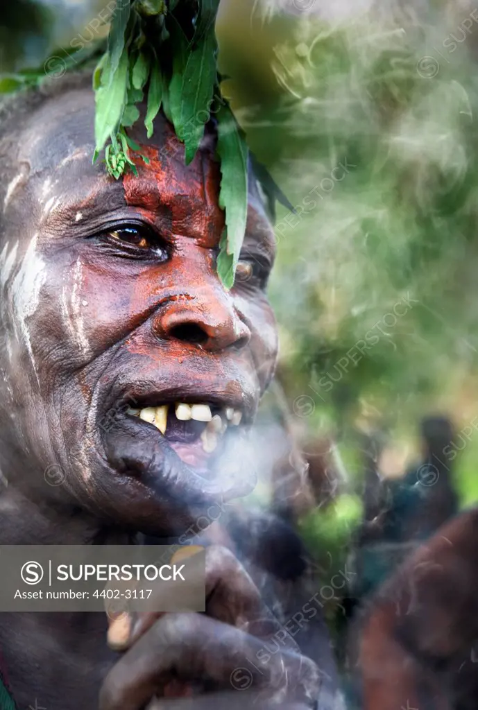 Suri tribeswoman with lip stretched for lip plate, smoking,  Omo Delta, Ethiopia