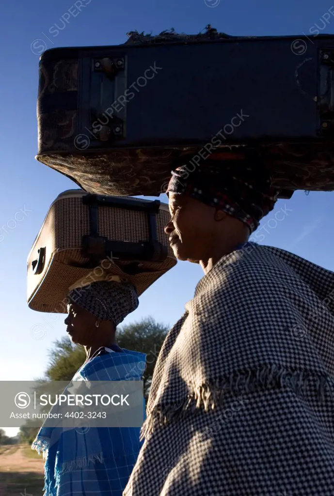Ndebele women carrying suitcases balanced on their heads, South Africa