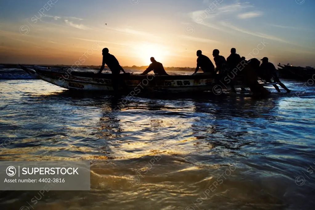 Fishermen launching a boat in the early morning, Yoff, Dakar, Senegal, west Africa