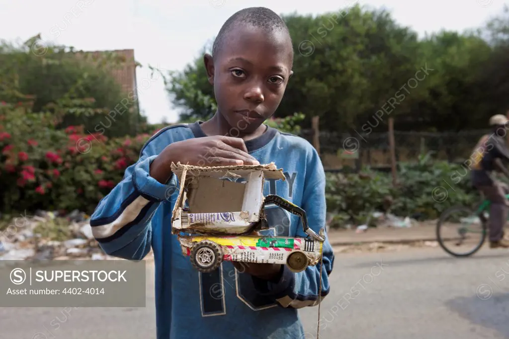 Boy with a toy car he has made, Nairobi, Kenya.
