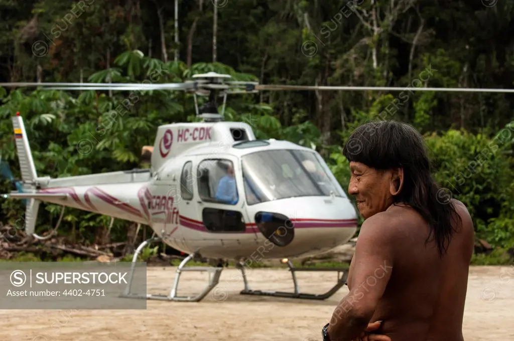 Huaorani Indian, Menga Darita, with helicopter. Gabaro Community, Yasuni National Park, Amazon rainforest, Ecuador, South America.
