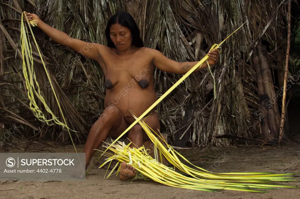 Huaorani Indian woman working with chambira, a fibre extracted from a palm leaf and used for shigras (string bags) and hammocks. Gabaro Community, Yasuni National Park, Amazon rainforest, Ecuador, South America.