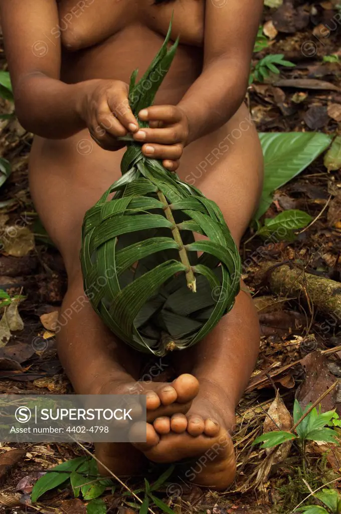 Huaorani Indian girl, making a basket from palm leaves which will be used once then discarded. Gabaro Community, Yasuni National Park, Amazon rainforest, Ecuador, South America.