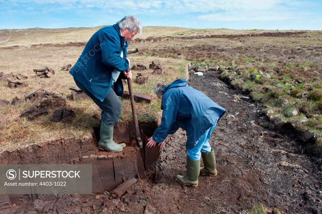 UK Scotland, North Uist, Two men digging turf