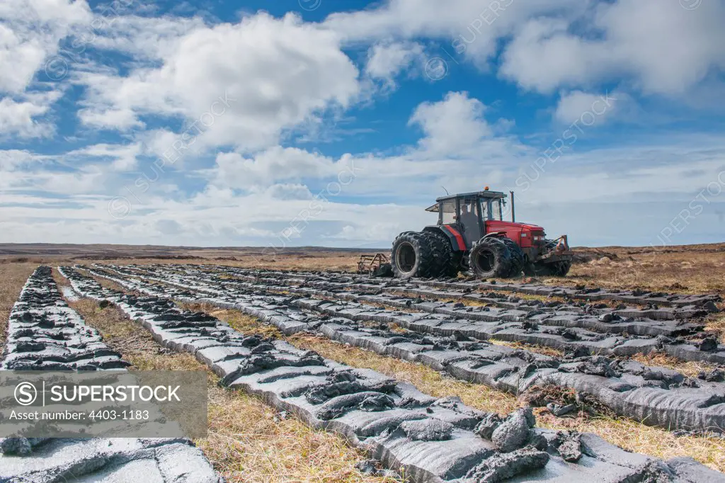 UK, Scotland, Hebredes, North Uist, Peat Digging use of tractor harvesting peat from moorland habitat