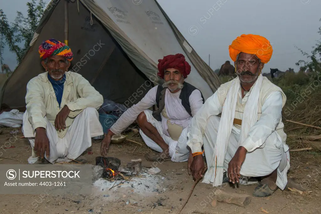 Rajasthani men at their camp warming by the fire Pushkar Camel Fair Rajasthan India