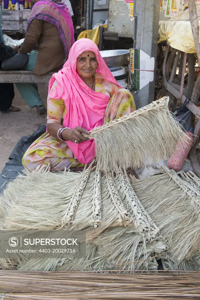 Rajasthani woman selling rafia sweeping brushes Sawai Madhopur Rajasthan India