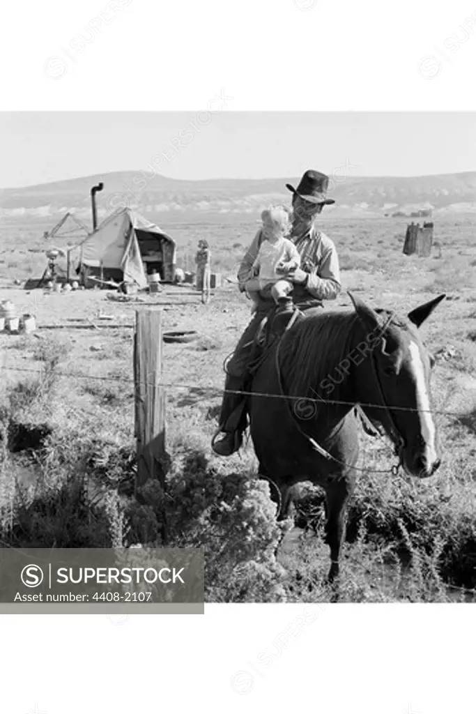 Cowboy holds his baby while riding a horse, Dorothea Lange