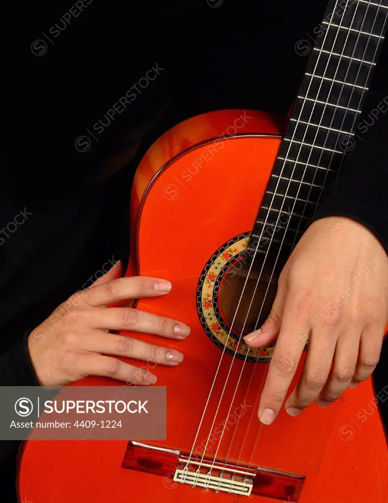Hands and flamenco guitar photo detail.