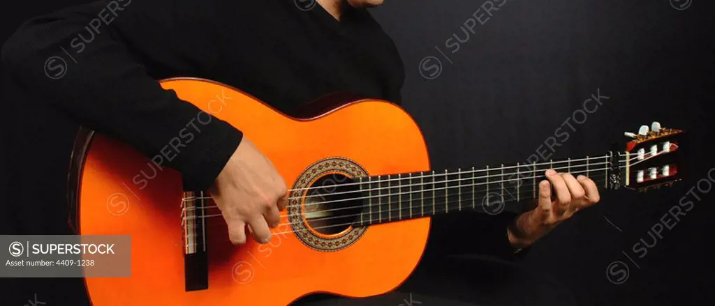 Photo detail of a guitarist playing the flamenco guitar.