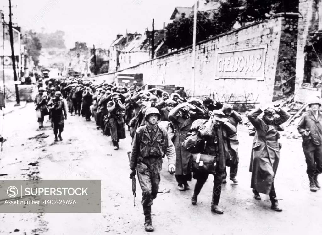 US GI's march German prisoners out of Cherbourg after the Battle of Cherbourg, June 1944.
