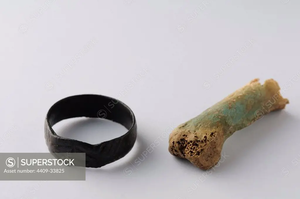 Bronze ring associated with bone phalanx. Ring 18 mm ( 5 th - 8 th Ce ) - Visigoth period, from the " Equinox Necropolis " - Archaeological site of Complutum in Alcalá de Henares ( Madrid ). SPAIN.