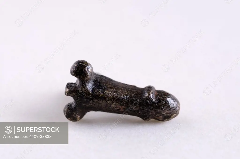 Bronze brooch with phallic shape. Length 11 mm Width 6 mm.( 1 St - 4 th Ce ). - Roman period, from the " Miracle Wall " ( Martyrdom of Saints Children ; Justo y Pastor ) -Archaeological site of Complutum in Alcala de Henares (Madrid). SPAIN.