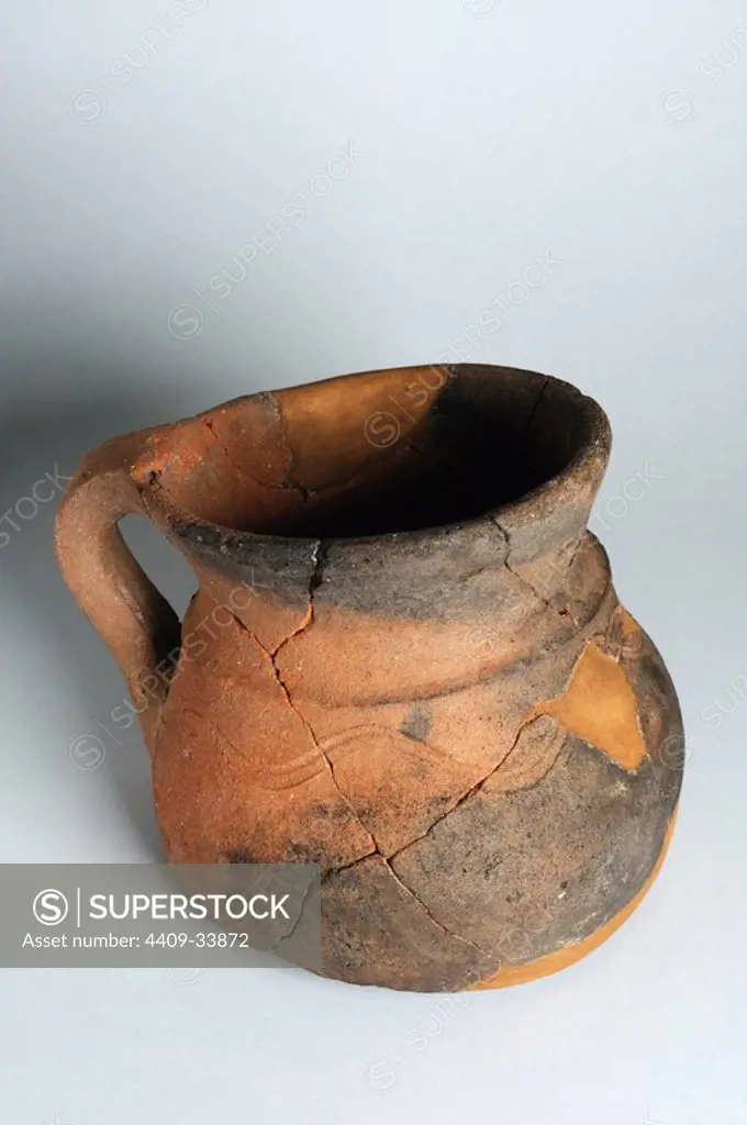 Ceramic jug with a handle and a rounded edge. has engraved rolling under the hull below the neck . Rim diameter 116 mm Height 121 mm Width 140 mm (6 th - 7 th CE ) - Visigoth period belonging of the " Burgo de Santiuste Museum" in Alcalá de Henares. (Madrid). SPAIN.