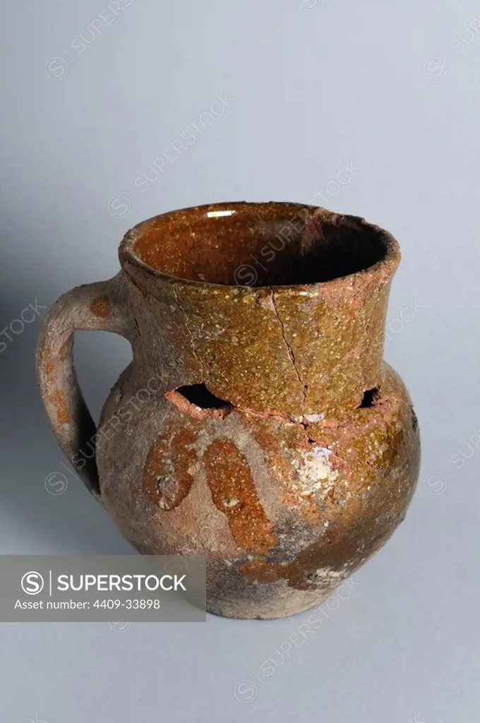 Glazed ceramic jug with a handle. Diameter edge 96 mm diameter base 60 mm Height 135 mm Width maximum 117 mm thickness 5 mm. (15 th - 17 th CE ) - Modern Age belonging of the " Burgo de Santiuste Museum" in Alcalá de Henares. (Madrid). SPAIN.