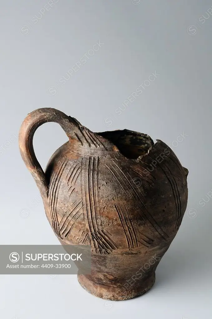 Two-handled jar with incised decoration to comb. Height 8, 5 cm Diameter 8 cm. (12 th-13 th) - Medieval period belonging of the " Burgo de Santiuste Museum" in Alcalá de Henares. (Madrid). SPAIN.