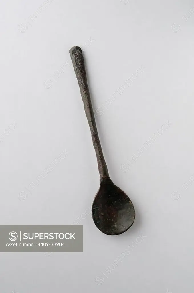 Spoon handle made of bronze . Length 12.3 cm Width 2, 7 cm - Medieval period from the archaeological site of the " Calle seises " in Alcalá de Henares - " Burgo de Santiuste Museum " (Madrid). SPAIN.