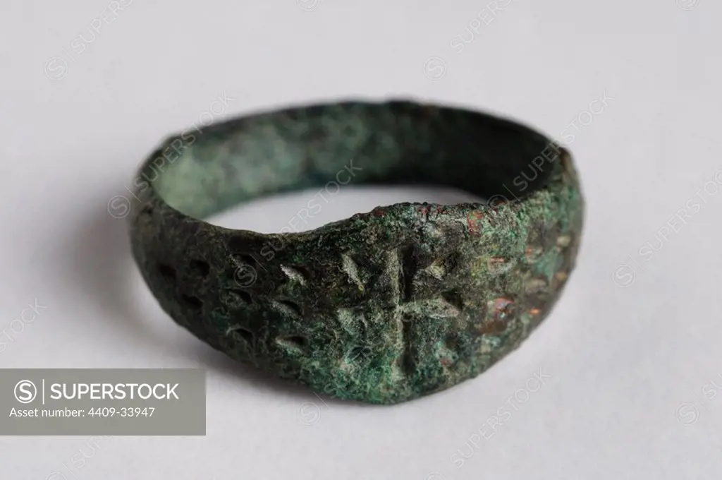 Bronze ring decorated with a Latin cross in bas-relief. Diameter 2 cm (1st - 5 th CE ) - Roman period, from the " Villa del Val" - Archaeological site of Complutum in Alcalá de Henares ( Madrid ). SPAIN.