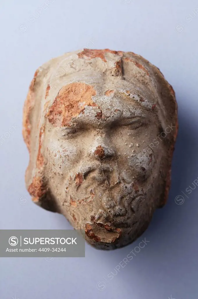 Terracotta antefixes representing a bearded head with clear slip .Height 7, 2 cm Width 5, 7 cm Thickness 4 , 2 cm ( 1 st - 5 th CE ) - Roman period from the necropolis of " Villa del Val " - Archaeological site of Complutum in Alcalá de Henares ( Madrid ). SPAIN.