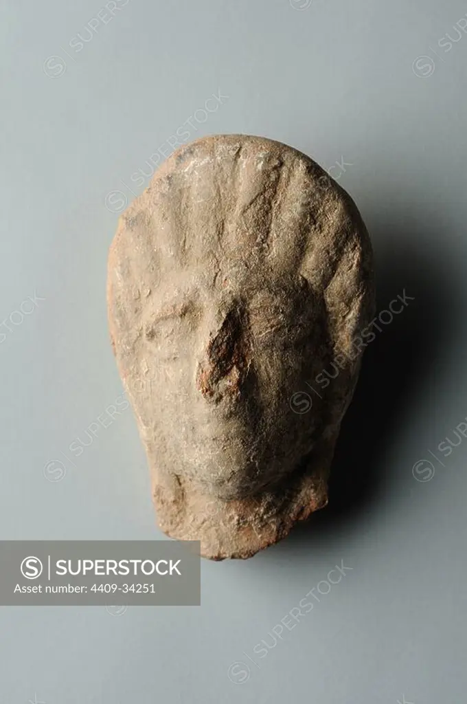 Head female of terracotta figurine with roman hairstyle. Height 6,6 cm Width 4 cm (1 st - 3 rd CE ) - Roman period, from " House of Griffins "- Archaeological site of Complutum in Alcalá de Henares ( Madrid ). SPAIN.