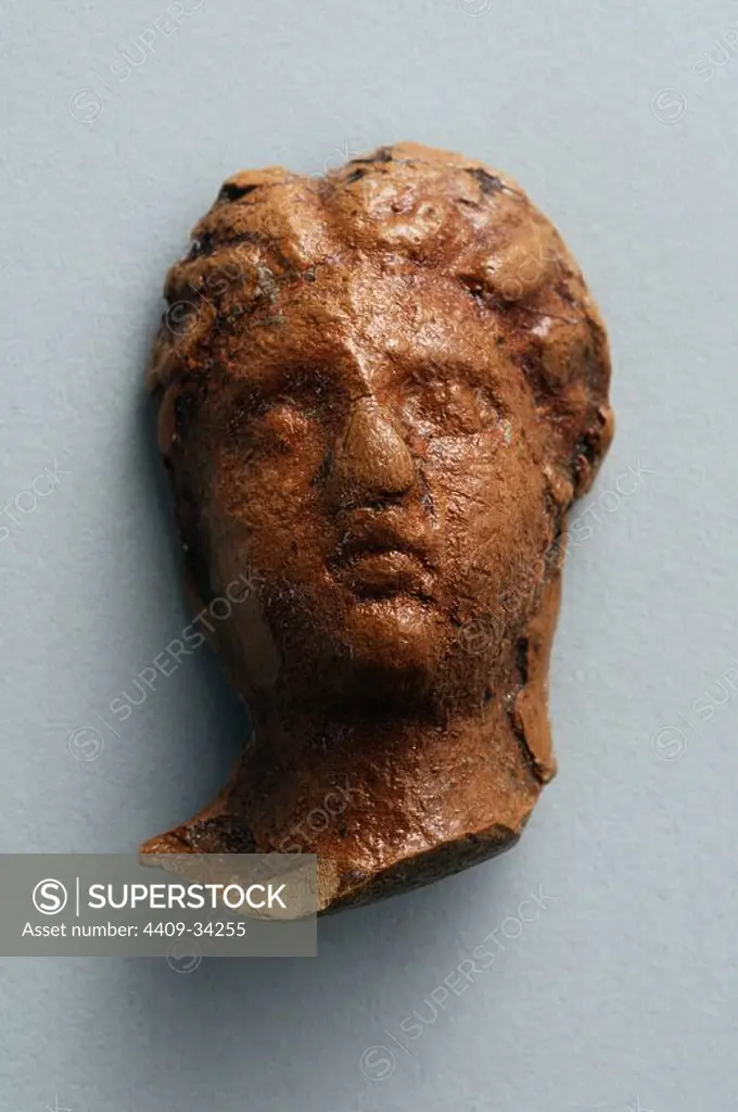 Head female of terracotta figurine with roman hairstyle. Height 3.6 cm Width 2, 3 cm (1 st - 3 rd CE ) - Roman period from " House of Hyppolytus "- Archaeological site of Complutum in Alcalá de Henares ( Madrid ). SPAIN.