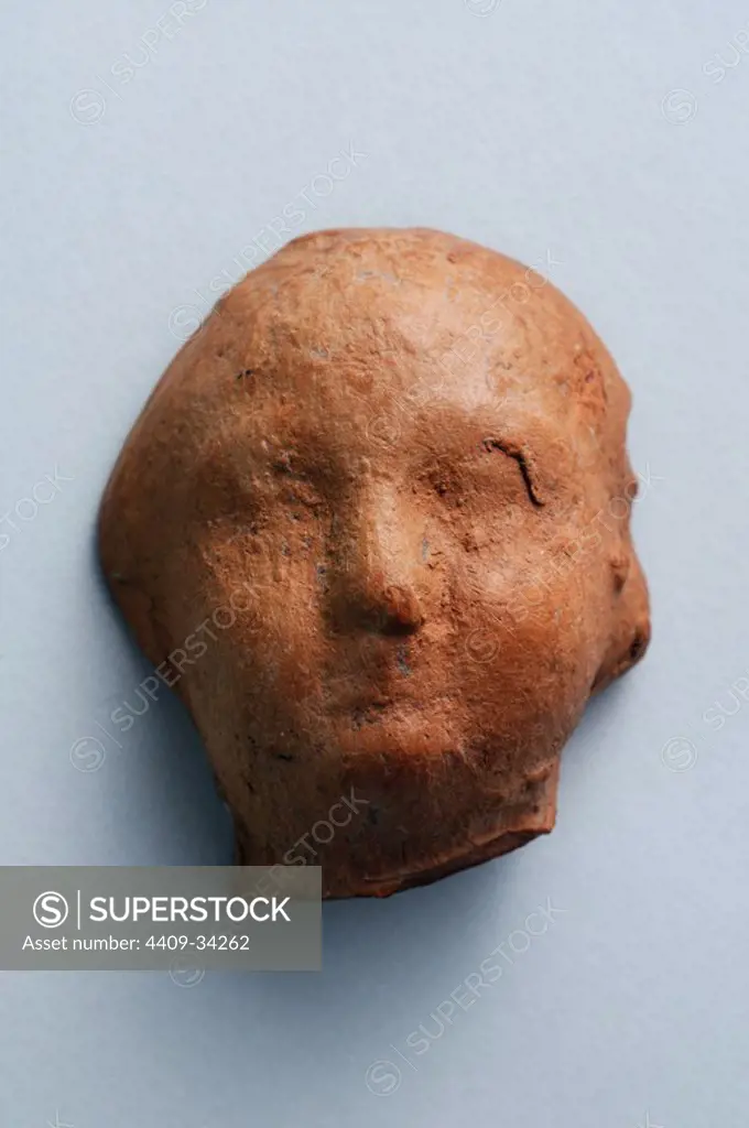 Child's head of terracotta figurine .Height 4 cm Width 3, 4 cm.(1 st - 3 rd CE ) - Roman period from " House of Griffins "- Archaeological site of Complutum in Alcalá de Henares ( Madrid ). SPAIN.