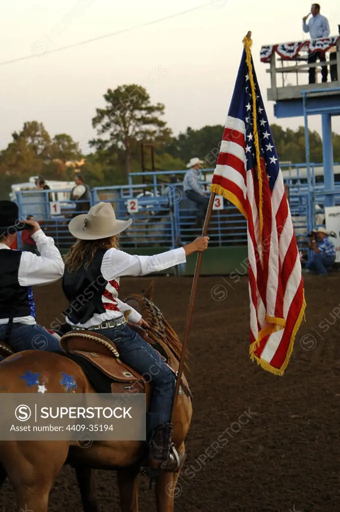 RODEO. Amazona con la bandera estadounidense. BASTROP. Estado de Texas. Estados Unidos.