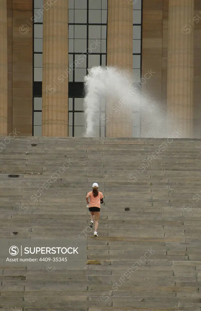 United States. Pennsylvania. Philadelphia. Woman jogging on the stairs of Philadelphia Museum of Art. The stairs are known for Rocky Steps, from the movie Rocky.