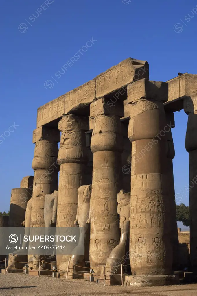 Temple of Luxor. Smooth shaft columns with closed papyrus capitals of the first court, built during the reign of Ramses II. Dynasty XIX. New Kingdom. Egypt.