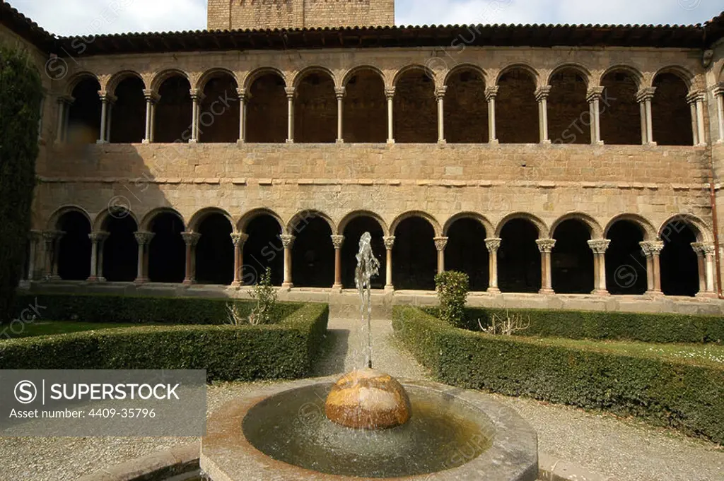 Romanesque Art. Monastery of Santa Maria de Ripoll. Founded by the Count Wilfred the Hairy in 879 or 880. Historic-artistic monument since 1931. Partial view of the cloister with a fountain in the foreground . Ripoll. Catalonia. Spain.