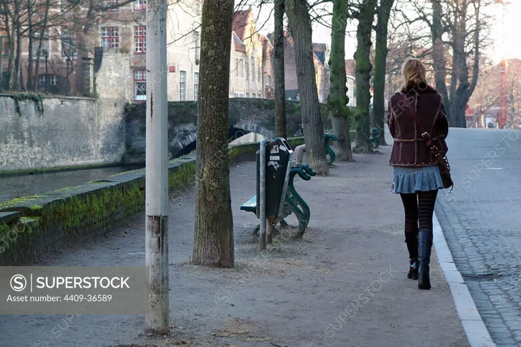 Mujer caminando por una calle de la ciudad. Brujas. Provincia de Flandes Occidental. Bélgica.