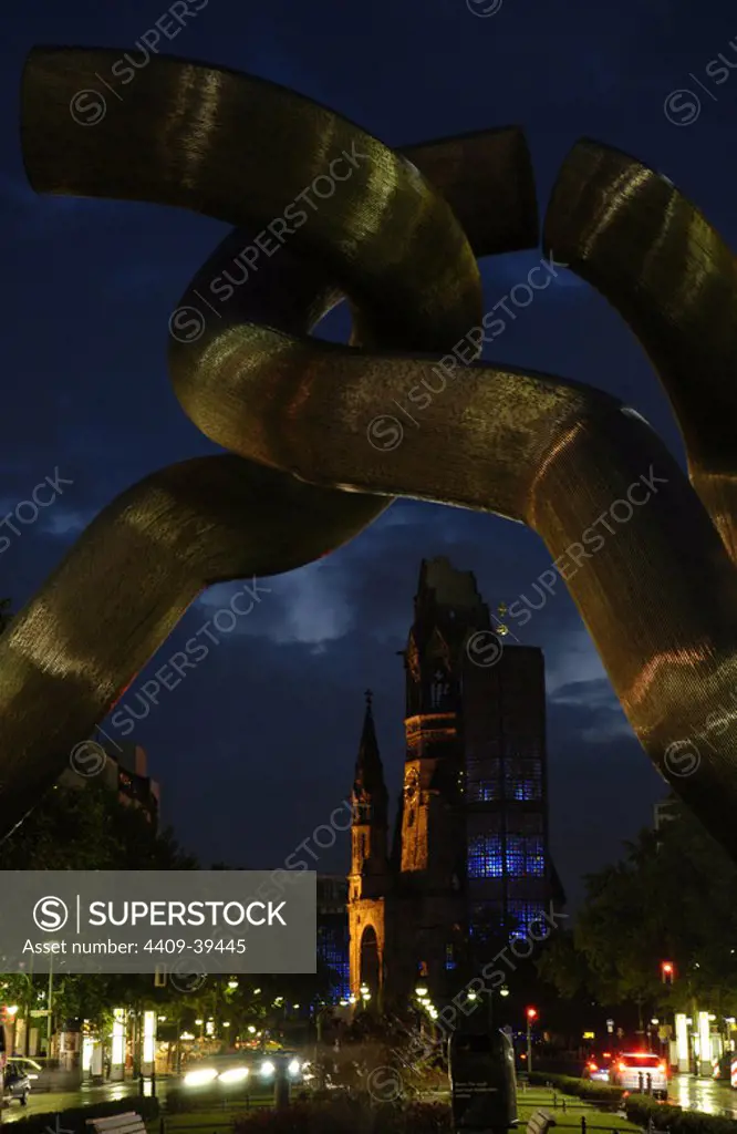 Germany. Berlin. Sculpture "Berlin", that empresses the broken nature of the city during the Cold War. Tauentzienstrabe. Background to the Kaiser Wilhelm Memorial Church. Nightly.