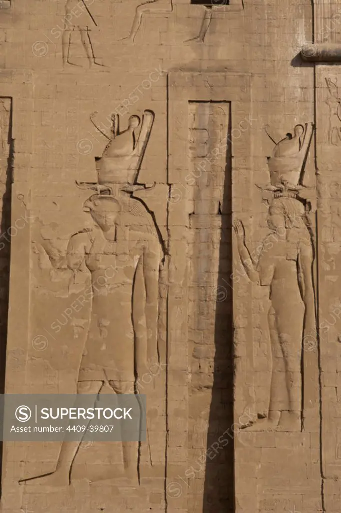 Temple of Horus. God Horus and goddess Hathor with double crown. Main entrance. First pylon. Detail. Edfu. Egypt.