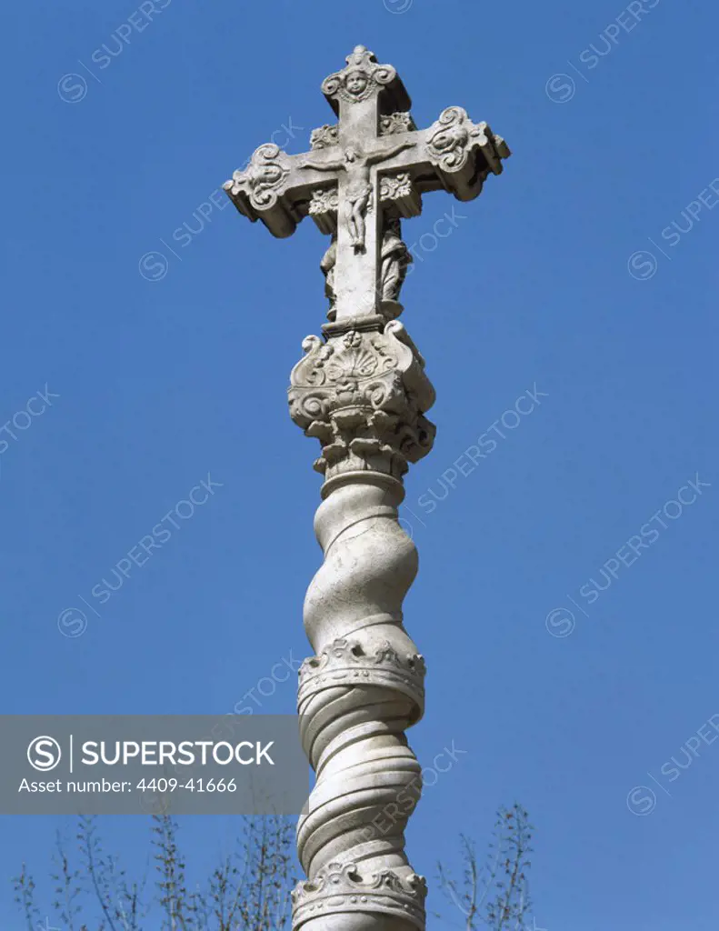 Baroque cross. Central courtyard of the Former Hospital de la Santa Creu. The sculptor Bernat Vilar restored the cross in 1691 as it was very old and seriously damaged. It is erected on a Solomonic marble column. Barcelona, Catalonia, Spain.