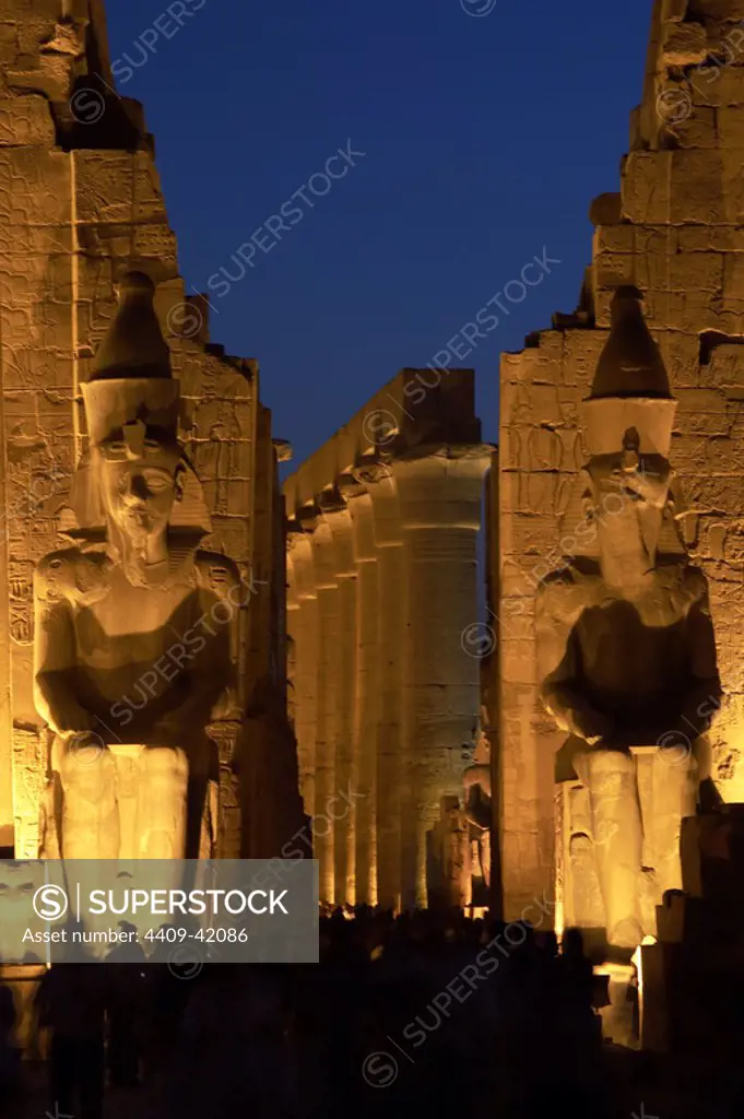 Temple of Luxor. Night view of the colossi of Ramses II in the first pylon of the temple. Egypt.