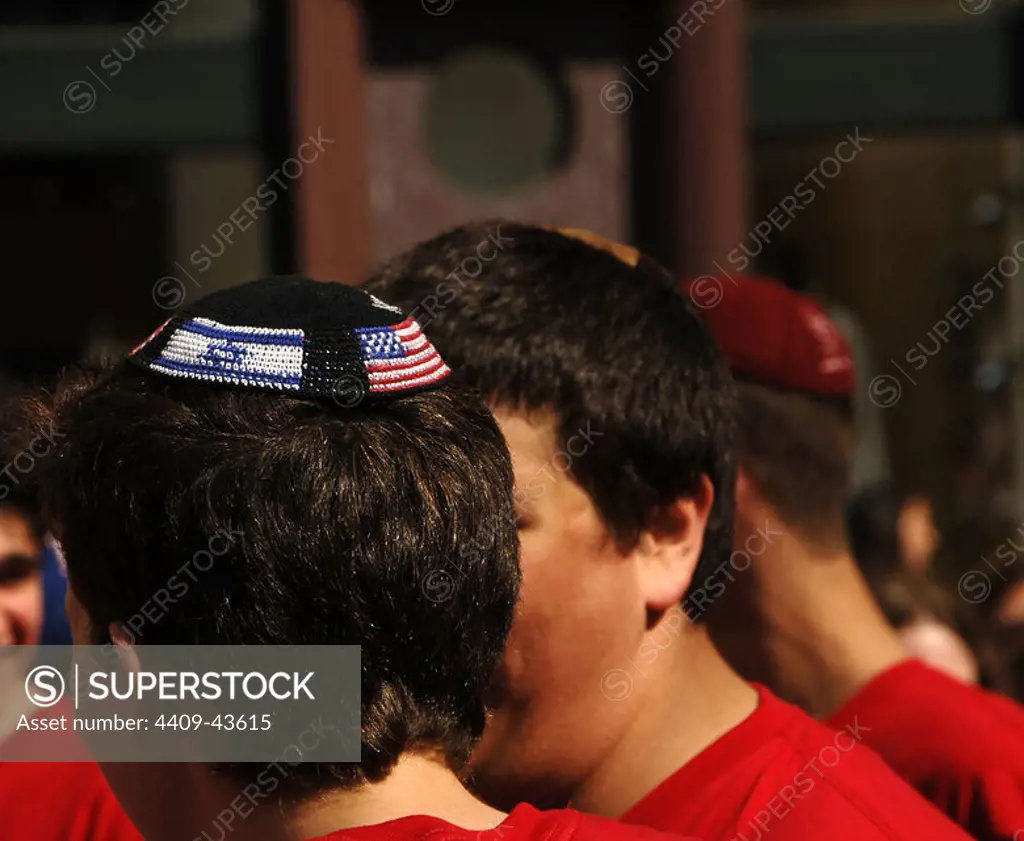 Young jewish with kippah or yarmulke with the American and Israeli flags. New York. United States.