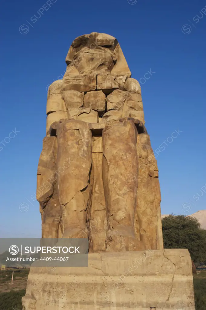 Colossi of Memnon. Stone statues depicting pharaoh Amenhotep III (14th century B.C.) in a seated position. Eastern colossus. Eighteenth Dynasty. New Kingdom. Luxor. Egypt.