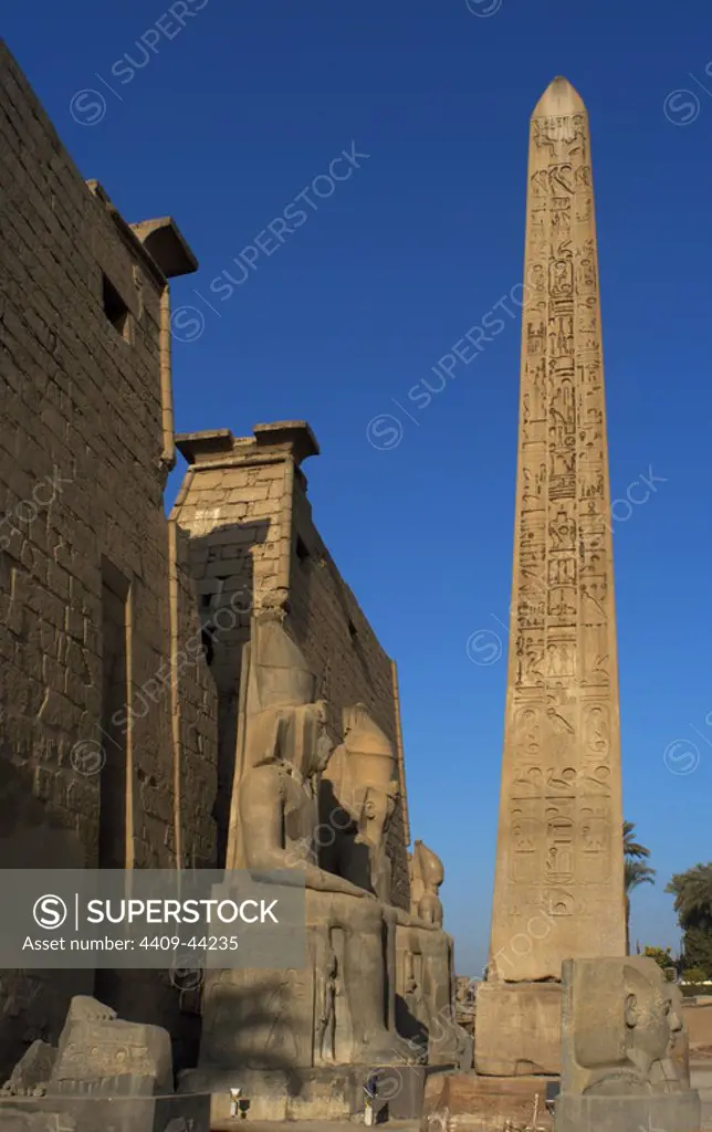 EGYPT. TEMPLE OF LUXOR. Partial view of the first pylon of the temple, the remains of an obelisk of pink granite, and head and colossal statues of Ramses II. Ancient Thebes "Waset,.