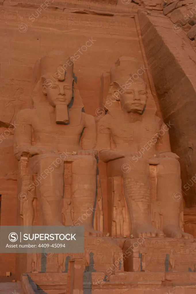 Egyptian art. Great Temple of Ramses II. Two colossal statues depicting the pharaoh Ramses II (1290-1224 BC) seated with the nemes head and surmounted by the double crown. 19th Dynasty. New Kingdom. Abu Simbel. Egypt.