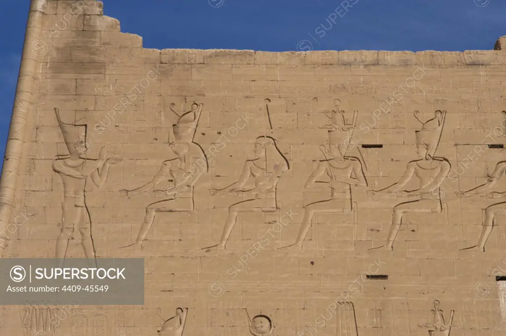 Temple of Horus. Pharaoh before gods. Main entrance. First pylon. Detail. Edfu. Egypt.