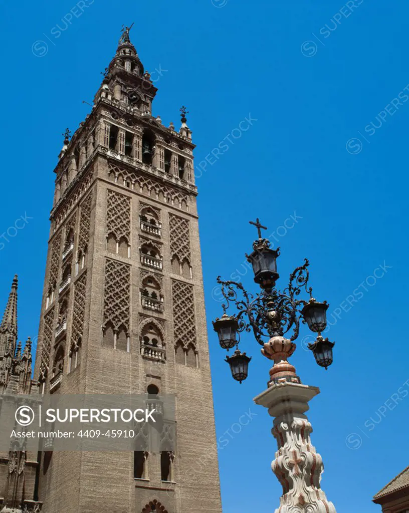 Andalusia. Seville. View of the Giralda tower (XIIth century). Minaret of the old mosque of the city and current bell tower of the cathedral. First, streetlamp. Spain.