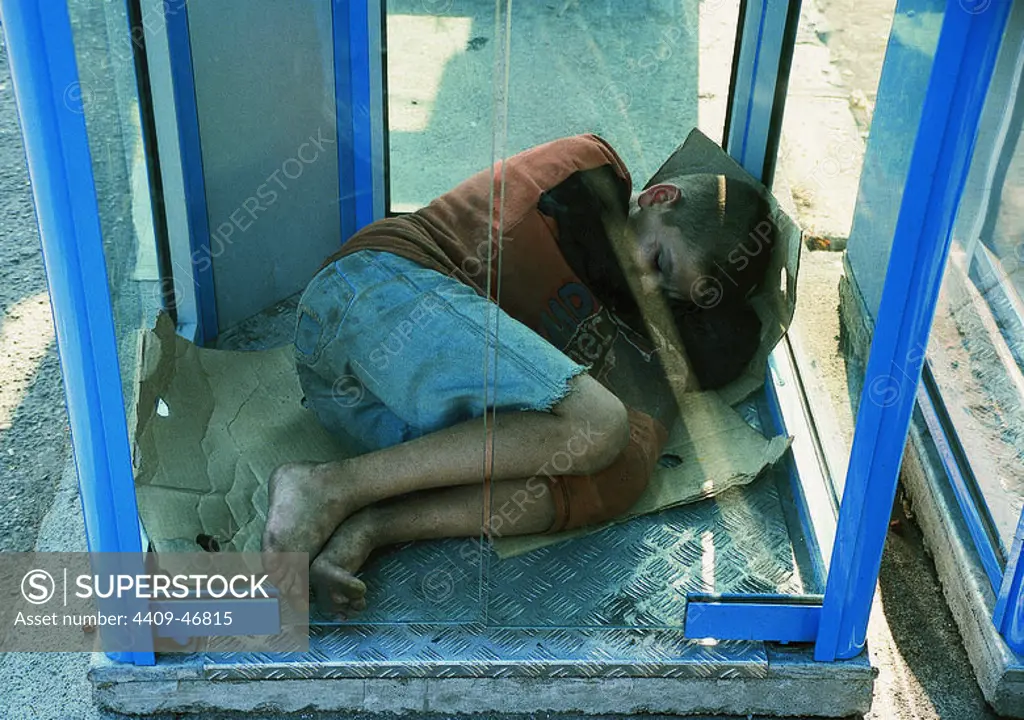NIÑO MENDIGO durmiendo en el interior de una cabina telefónica. BUCAREST. Rumanía.
