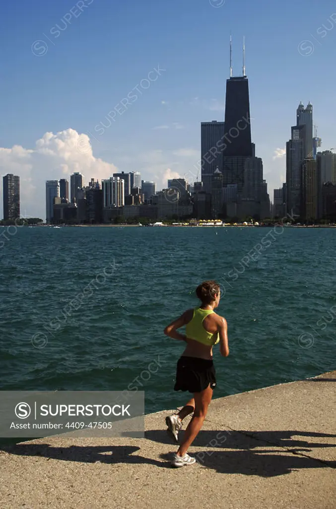 Mujer joven haciendo footing junto al Lago Michigan. Al fondo, los rascacielos del centro de la ciudad. CHICAGO Estado de Illinois. Estados Unidos.