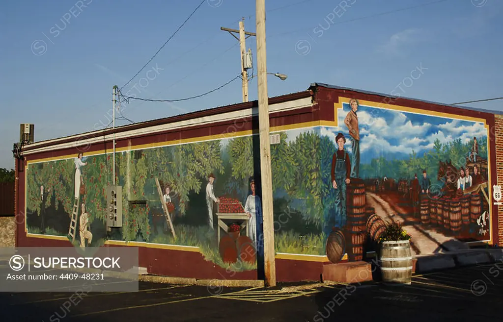 History of the United States. 20th Century. Wall painting depicting day laborers picking apples that will later be transported in barrels by train. By Shelly Smith Steiger. Series of murals depicting historical scenes of both local and national themes. Cuba, State of Missouri, United States.