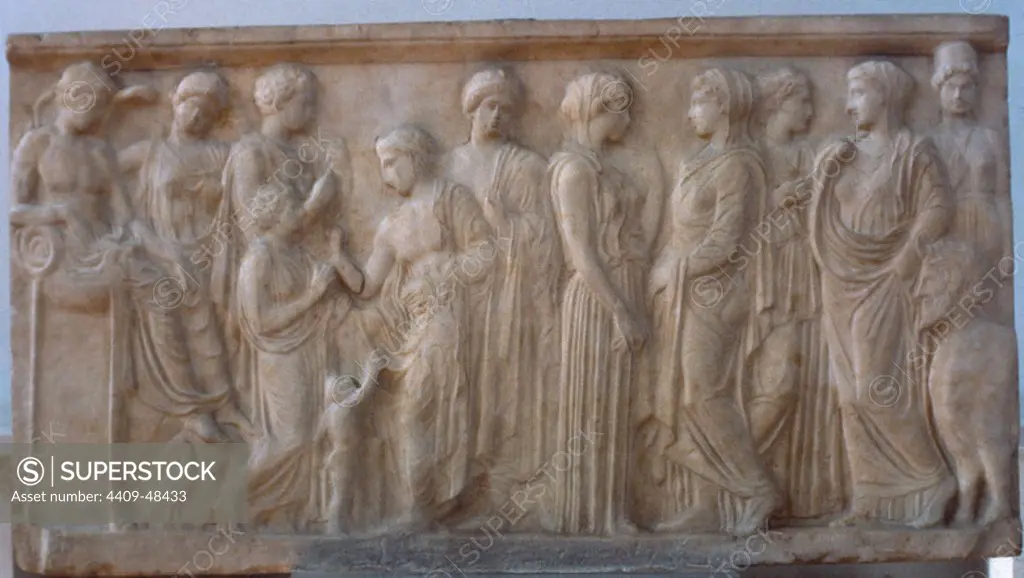 EXVOTO DE XENOKRATEIA y su hijo (s. IV a. C.) junto a una figura masculina, que le escucha, el dios del río CEFISO. A la izquierda, APOLO, sentado sobre el caldero de su trípode de Delfos, y otras divinidades: HESTIA, LAFONA, ARTEMIS, ELICIA, KALIROE, NINFAS y el dios acuático AQUELOUS (toro con cabeza humana). Pieza hallada en Neon Phaleron. Museo Arqueológico Nacional. Atenas. Grecia.