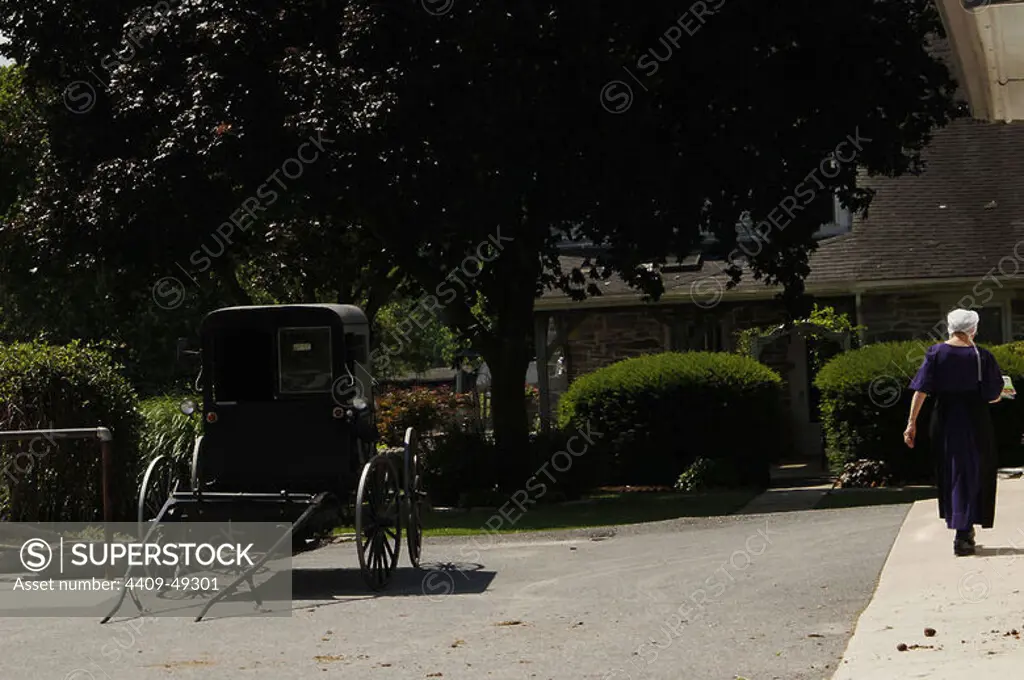 Amish woman walking in the street. Lancaster County. United States.