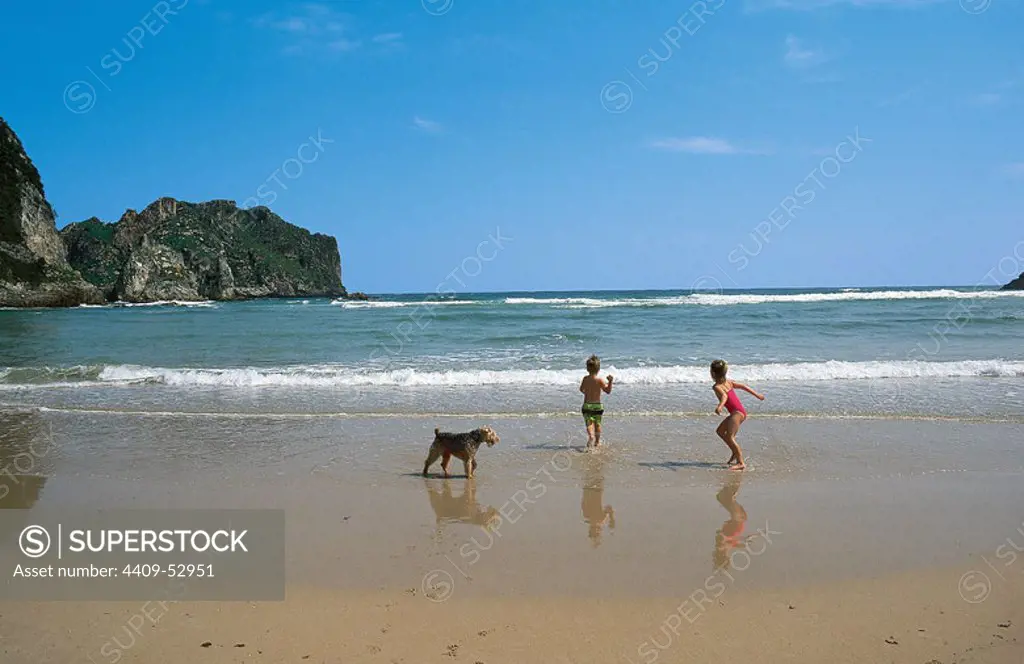 Niños jugando a la orilla del mar en la PLAYA DE LA FRANCA, en la costa oriental asturiana. LA FRANCA. Asturias. España.