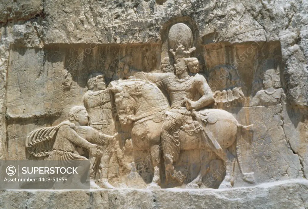 ARTE PERSA-PERIODO SASANIDA. Bajorrelieve del "TRIUNFO DE SEPUR I", donde se narra la rendición de los emperadores VALERIANO y FILIPO "el Arabe" tras las campañas de 252-261. A caballo el rey sasánida y arrodillado ante él, Valeriano, su prisionero hasta su muerte. Relieve del s. III d. C. NAQSH-E ROSTAM (Naqsh-e Rustam). Provincia de Fars. República Islámica de Irán.